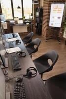 Modern office with nobody present is organized with computer systems and multiple chairs. A well arranged brick wall workplace, ready for company analysis and marketing discussions among employees. photo
