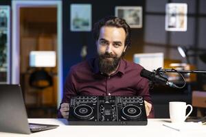 Content creator filming technology review of newly released DJ controller, unboxing it, excited to look at specifications. Influencer showcasing sound mixer device to viewers photo