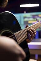 Skilled producer recording his song on guitar to mix and master music on daw software, working with post production equipment. Sound engineer creating soundtracks in home studio. Close up. photo