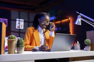 Woman in workspace watching funny videos on social media using laptop. Person using social network website on notebook, amused by hilarious content, slacking off at work in home office photo