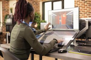 African American designer refining projects on digital monitors, enhancing visuals in modern creative workspace. Black woman focused on editing and 3D modeling, working across multiple screens. photo