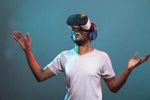 Excited male model wearing VR glasses, engaging in a 3D simulation with advanced modern technology for entertainment. Black man having fun in virtual reality interface against an isolated background. photo