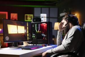 Sad person feeling upset after losing internet competitive multiplayer videogame match. Depressed gamer feeling down after being defeated in videogames, seeing game over message photo