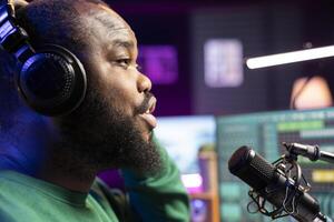 Talented musician expert singing a track on a microphone, performing in home studio to adjust volume levels with amplifier gear. Composer recording his song and editing. Close up. photo