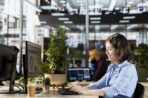 Office employee examining performance metrics numbers at the workplace, working on budget analysis and financial report as a business operation. Multinational company management. photo