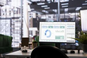 Modern office desk displays financial data on a monitor. The detailed analytics and graphs highlight business strategy and success, supported by data management and analysis tools. photo