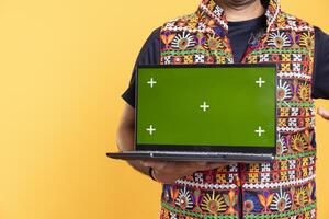 Man holding green screen laptop, using it for solving projects in office for company, studio background. Close up shot of employee using mockup notebook device at work to solve job tasks photo