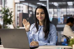 Indian employee engages in an online meeting with her team, discussing project briefs and upcoming deadlines. Using call to ensure seamless communication and time management. photo