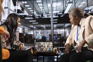 Diverse group of businesswomen participate in a remote conference call, showcasing leadership and cultural diversity for a successful business in an inclusive workspace. Setting tasks in a meeting. photo