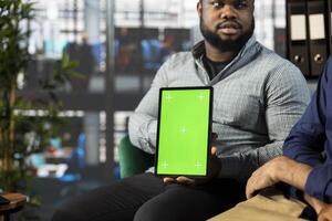 Green screen tablet next to manager talking with employee, coordinating company administrative operation. Supervisor reviewing business procedures on mockup device, discussing with worker photo