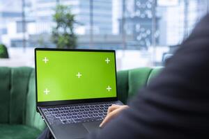 Leader in a high end corporate office looks at green screen and analyzes financial data, setting company objectives and implementing strategic planning for long term business success. photo