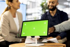 Focus on isolated screen tablet next to employees implementing business strategies to improve operational efficiency. Close up of mockup device next to office workers in blurry background photo