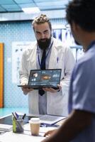 Neuroscience expert reviewing mri brain scan results with doctors, discussing the right treatment plan for disease prevention. Licensed neurologist and his staff examine tomography. photo