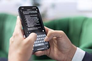 Bucharest, Romania - July 30th 2024 - Man typing prompts into an AI powered chat on his smartphone app, advanced virtual assistant showcases smart solutions for task completion. photo