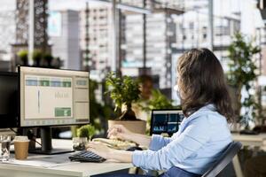 Female employee reviewing company data to work on a new strategy and plan expansion, managing resource allocation and effective business tasks. Analyst does financial forecasting. photo