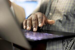 Office clerk reading company documents on laptop, checking progress on customer commissioned project tasks. Staff member comparing key data statistics on notebook after business audit photo