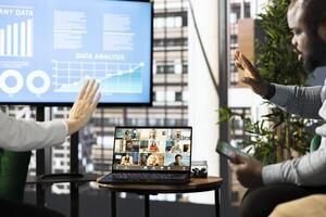 Managers waving hand, chatting with collaborators working from home, holding videoconference meeting using laptop to present new project. Supervisors saluting workers in remote videocall photo