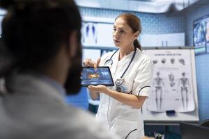 Doctor neurologist showing mri brain scan results to her colleagues, meeting in a cabinet to examine x rays and put a diagnostic. Analyzing tomography tests, neuroscience and radiology. photo