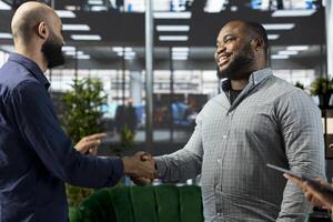 Smiling Middle Eastern interviewer holding meeting with job candidate, doing handshake, asking questions and presenting company background. Jolly Arab HR employee interviewing man photo
