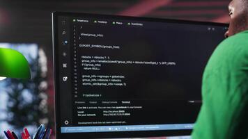Black system administrator creating a software with programming language. Professional engineer focuses on app development, debugging, encryption and security at home. Camera A. video
