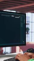 Vertical Black guy uses deep learning tools to generate footage from text prompts in a productive home environment. Freelancer uses computer to display montage. Camera B. video