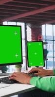 Vertical African american person using an isolated display on computer at home, working on his daily assignments on freelancing platforms. Young guy solving tasks from his loft, home setup. Camera B. video