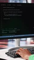 Vertical Male programmer types code on computer and running script, programming language. African american IT expert in modern loft fixing errors within the software, implementing new features. Camera A. video