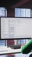 Vertical Black IT expert looking at user interface on computer at home office, typing and programming code on terminal window. Coding application used by technician writing script in loft. Camera B. video
