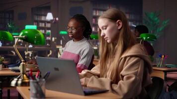 Female student reading and writing detailed notes for an exam, studying political science for upcoming lecture in a library setting at the university. Young adult consults a colleague. Camera A. video