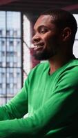 Vertical African american remote worker at home doing online research, writing down and gathering important data. Teleworker focused on reading articles, daily assignments at home. Camera A. video
