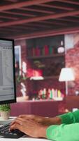 Vertical Freelance developer writing code in a modern programming language. Young man analyzes big data, algorithms and optimizing performance while using binary code at home office. Camera B. video