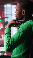 Vertical African american guy exploring art and deep learning visuals on a monitor. Uses predictive technology, virtual assistants and programs to bring prompts to life. Camera A. video