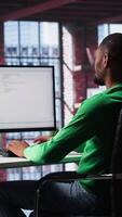 Vertical African American IT expert working with a computer full of code. Professional system engineer focuses on software development, debugging, encryption and system security at home. Camera A. video