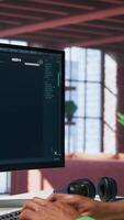Vertical African american user operates program to create digital photos in modern loft. Man explores creative visualization with artificial intelligence tools, with prompts. Camera B. video