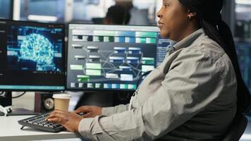 Data center computer scientist using artificial intelligence deep learning models to configure hardware. IT specialist using AI programming languages on PC in server farm, optimizing system, camera B video