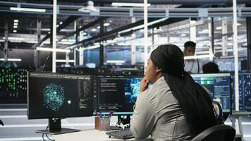 Data center admin does machine learning node tree programming, optimizing resource allocation. Server room worker uses predictive artificial intelligence visualization systems for maintenance, camera A video