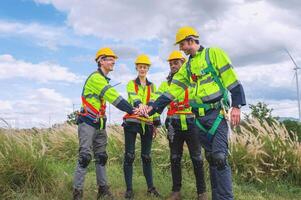 group of construction workers are holding hands in a field photo