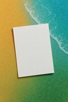Minimalist white card resting on a colorful gradient background resembling sand and sea, perfect for a beach-themed invitation design. photo