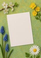 Blank card surrounded by spring flowers, perfect for invitations or greetings on a green mottled background, ready for your personal touch. photo