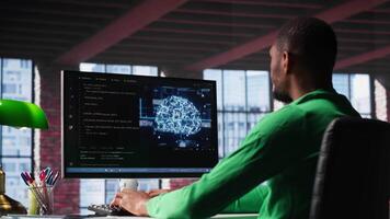 Black tech engineer programming an AI brain neural network for machine learning, doing maintenance and debugging the software systems. Technician expert uses coding language. Camera A. video