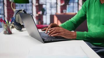 Freelancer creating articles content for his online blog at home desk, writing and working on storytelling with his laptop. Black guy composes social media posts, multitasking. Camera B. video