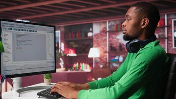 Freelance developer writing code in a modern programming language. Young man analyzes big data, algorithms and optimizing performance while using binary code at home office. Camera B. video