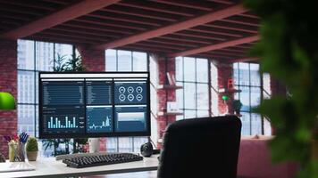 Monitor showcases business trends and targeted marketing development, SEO tools and analytics in an empty loft apartment with a spacious modern interior and a minimalist desk setup. video