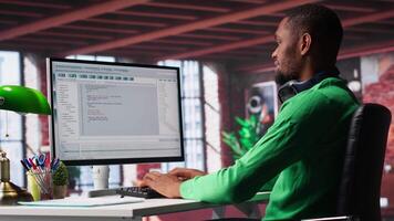 Tech savvy black engineer developing secure online program at home. Surrounded by binary data, freelancer works on interface design, script optimizations and network systems. Camera A. video