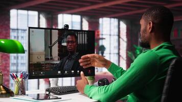 Male worker calls manager remotely using internet call to ask for feedback on project progress. Teleworker requesting assistance from team leader in teleconference meeting. Camera A. video