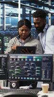 Vertical Smiling server hub engineers collaborating, using AI algorithms and node tree systems to categorize unstructured data. Colleagues use visual programming and natural language processing tools, camera A video