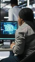 Vertical Data center coworkers doing brainstorming, using artificial intelligence machine learning models to configure equipment. IT experts cooperating in server farm, working on optimizing systems, camera B video
