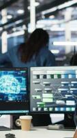 Vertical Technician in wheelchair and data center manager using AI node tree software to minimize system downtime. Server hub employee in disability and team leader using visual programming tool, camera B video