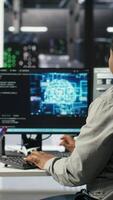 Vertical Technicians in AI server hub collaborate to protect against data theft during active threat. Data center team working together to safeguard equipment and systems during security breach, camera B video