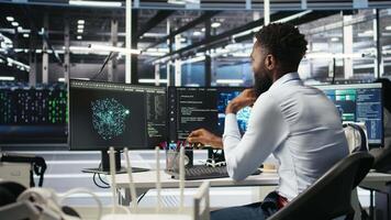 Data center programmer uses neural networks node tree program to identify equipment issues. Server hub employee reviewing AI deep learning data analysis graph to minimize failures, camera A video